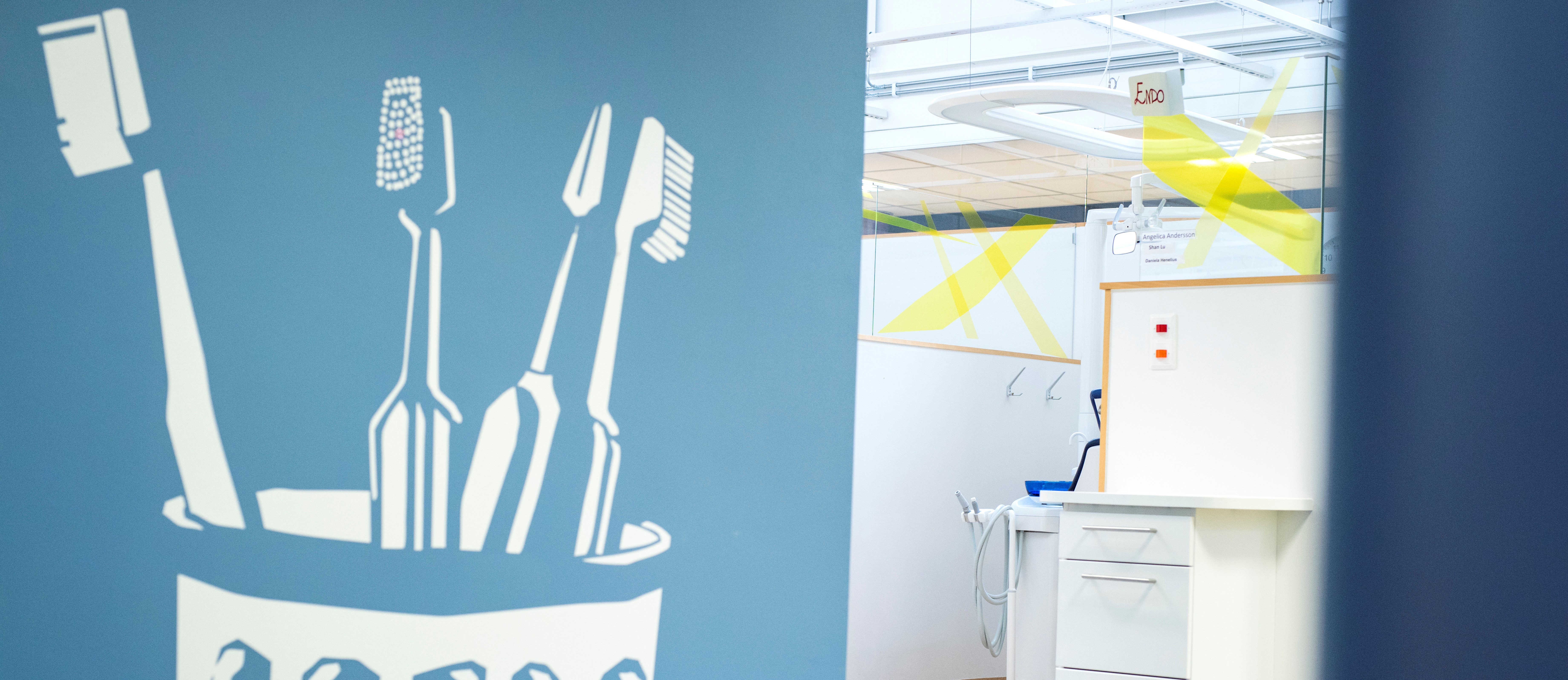 En ljusblå bakgrund med ett ritat tandborstglas i vitt, i glaset står 4 stycken vita ritade tandborstar, dom ser helt nya och oanvända ut. 