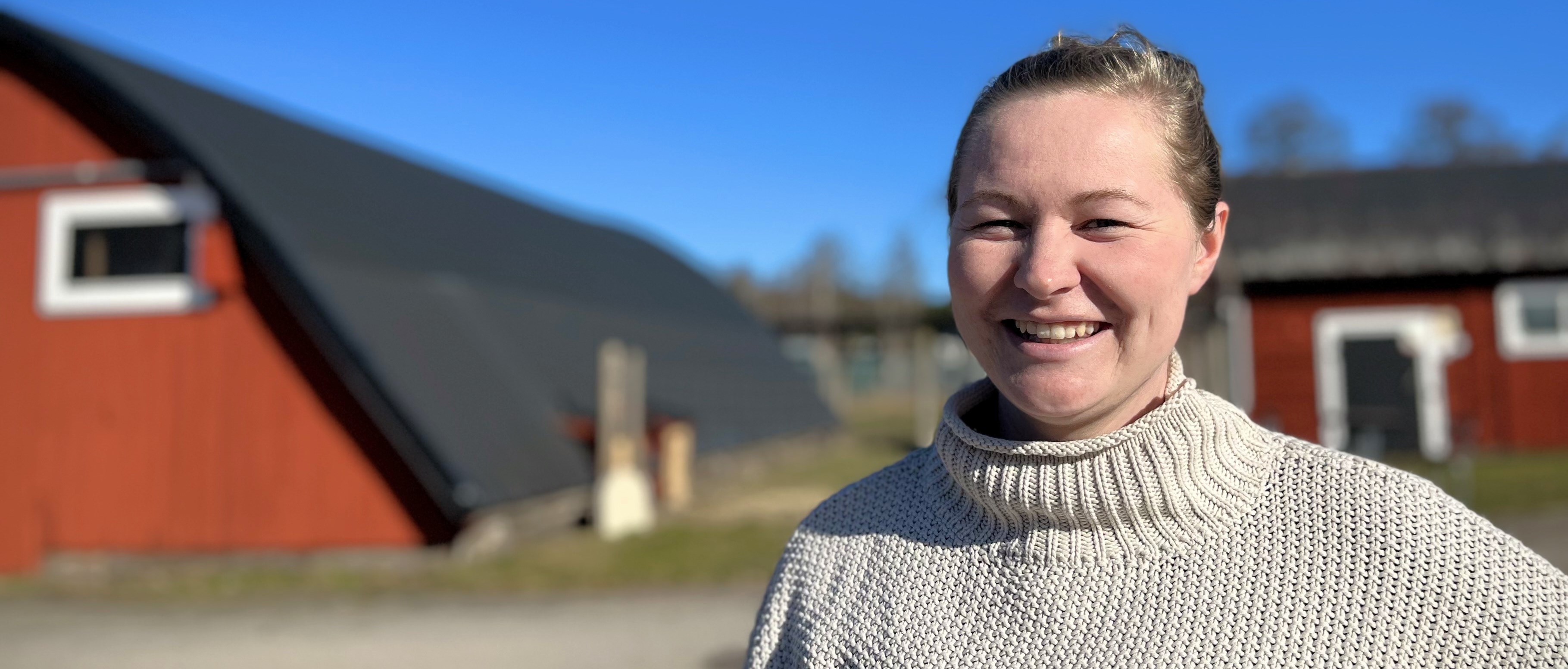 Jenny Hermansson framför ladugårdsbyggnad på Sötåsen
