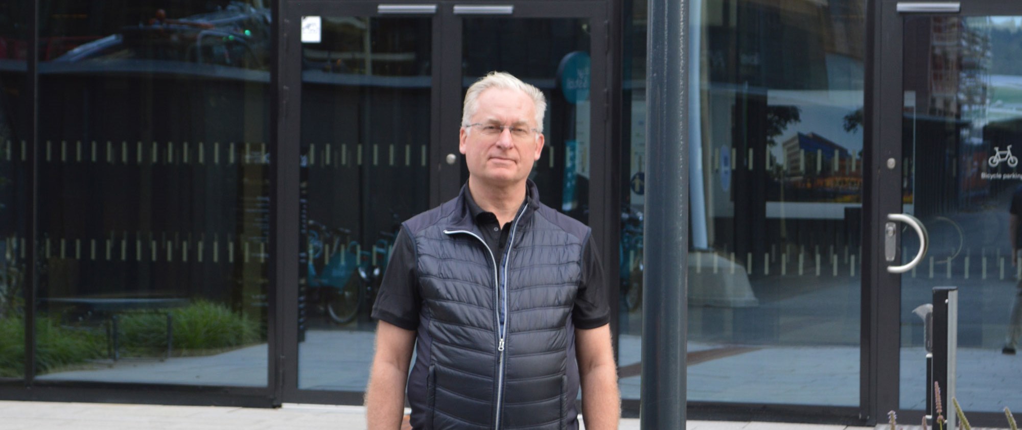 Dennis -larsson står framför GoCo houses glasbeklädd fasad