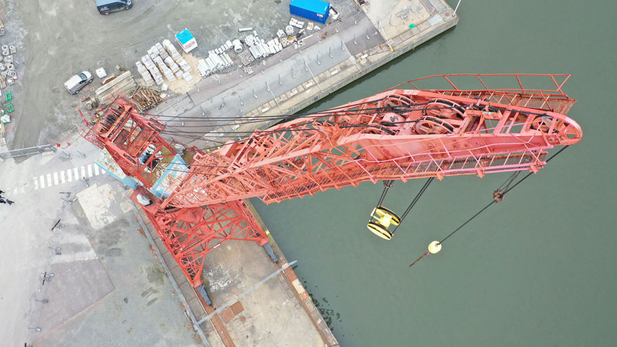 Ovanifrån, kranens lyftarm är sträckt uppåt.