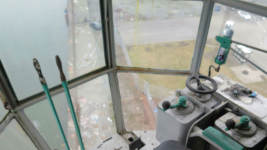 Inifrån styrhytten, en stol, långa spakar, rattar, stora fönster