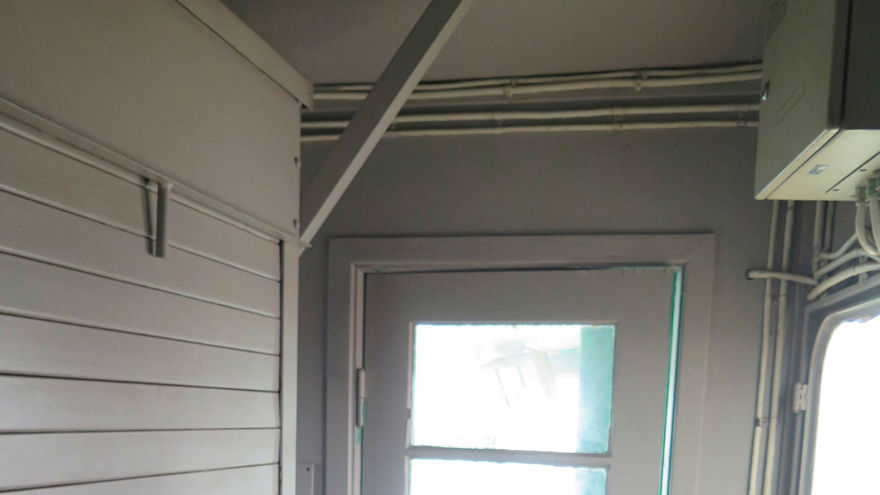 Inifrån kran 43, dörr som leder ut och brandsläckare, vita väggar